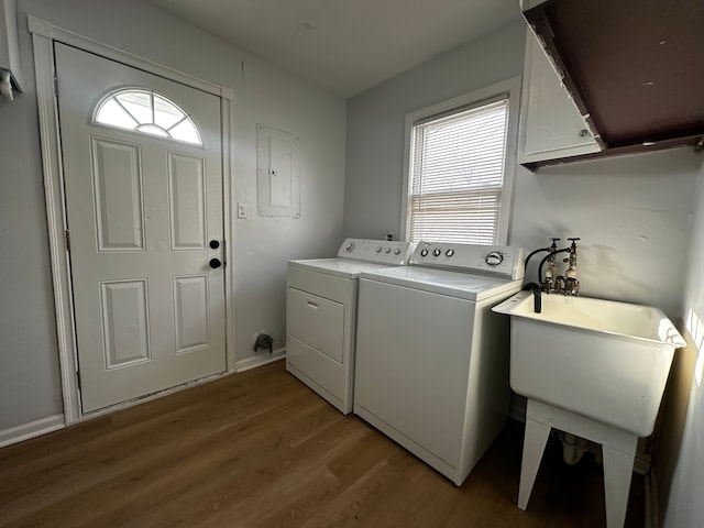 washroom with washer and clothes dryer, electric panel, light wood-style floors, cabinet space, and a sink