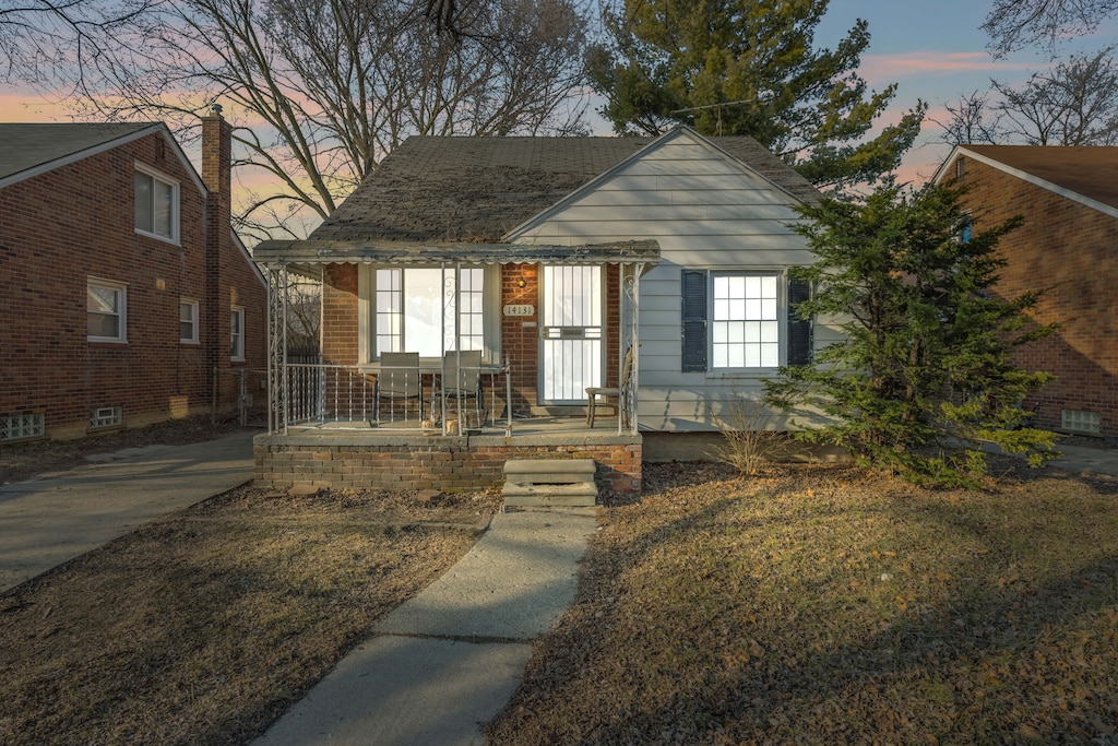 bungalow with brick siding and covered porch