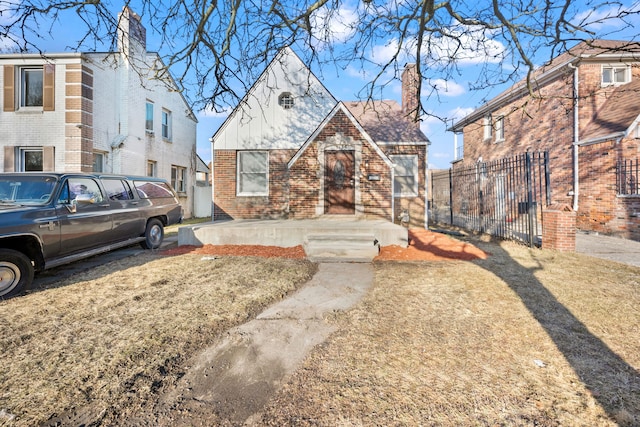 view of front of house featuring brick siding and fence