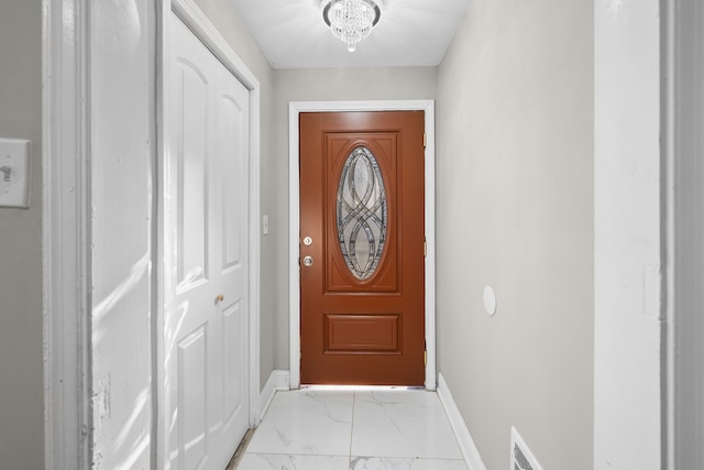 doorway with visible vents, baseboards, and marble finish floor