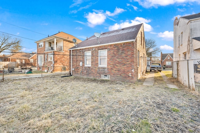 back of property featuring brick siding and fence