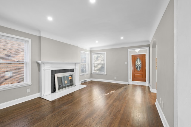 unfurnished living room with recessed lighting, a brick fireplace, baseboards, and dark wood-style flooring