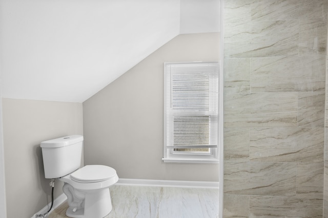 bathroom featuring toilet, baseboards, and vaulted ceiling