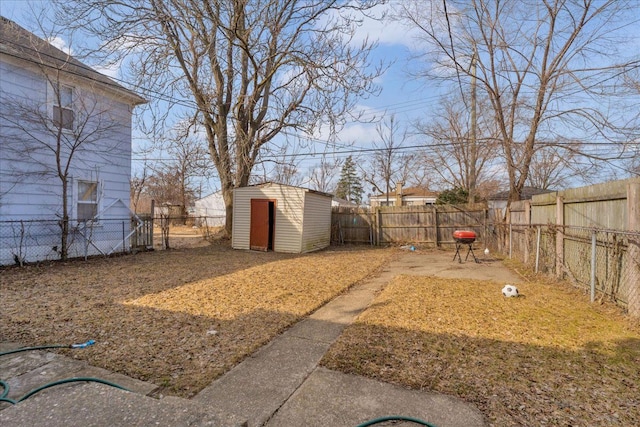 view of yard with an outdoor structure, a fenced backyard, and a shed