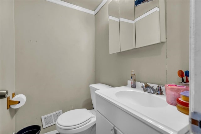 half bath with visible vents, toilet, vanity, and crown molding