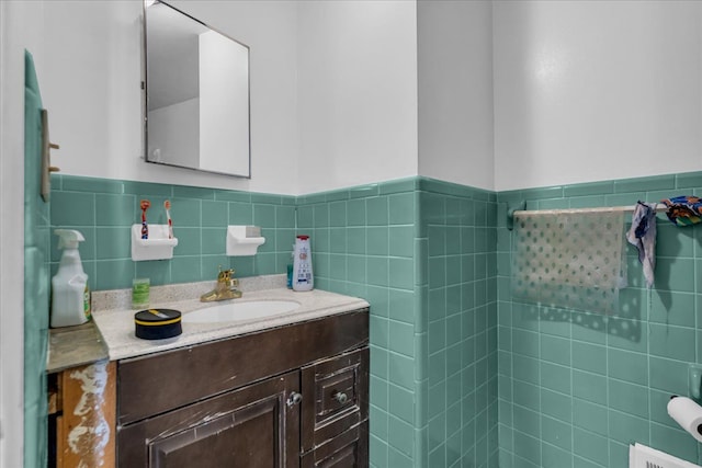 bathroom featuring wainscoting, vanity, and tile walls