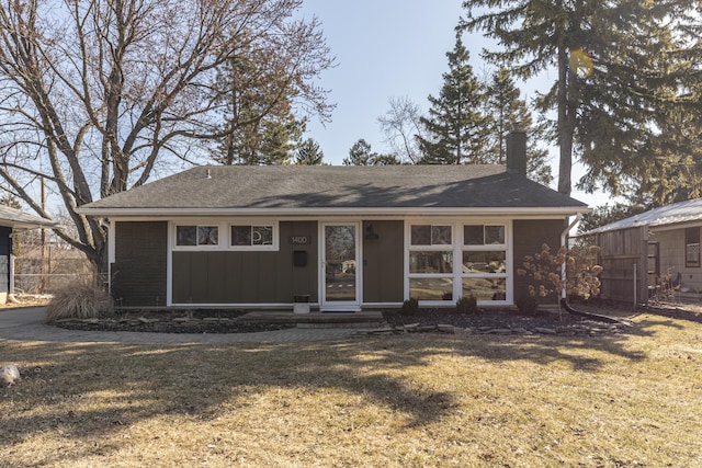 single story home with entry steps, a front yard, and roof with shingles