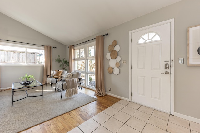 entrance foyer with baseboards, light wood finished floors, and vaulted ceiling