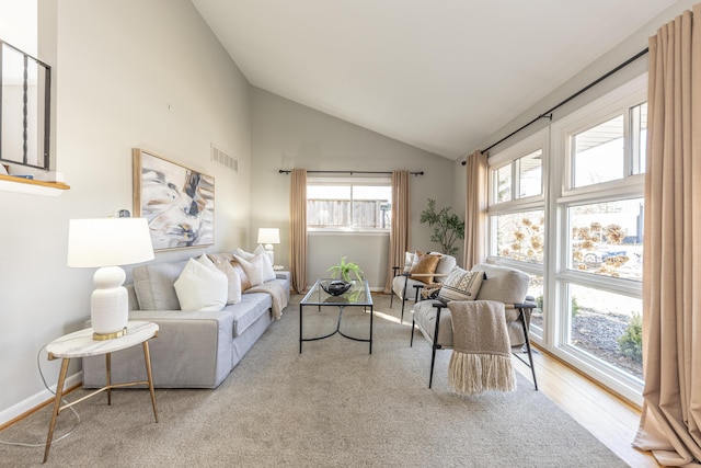 living room featuring baseboards, visible vents, and high vaulted ceiling