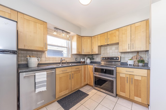 kitchen featuring light tile patterned floors, a sink, stainless steel appliances, under cabinet range hood, and tasteful backsplash