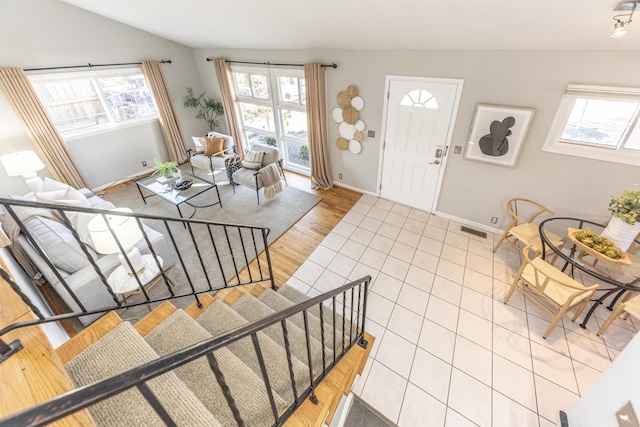 foyer with visible vents, baseboards, a healthy amount of sunlight, and stairway