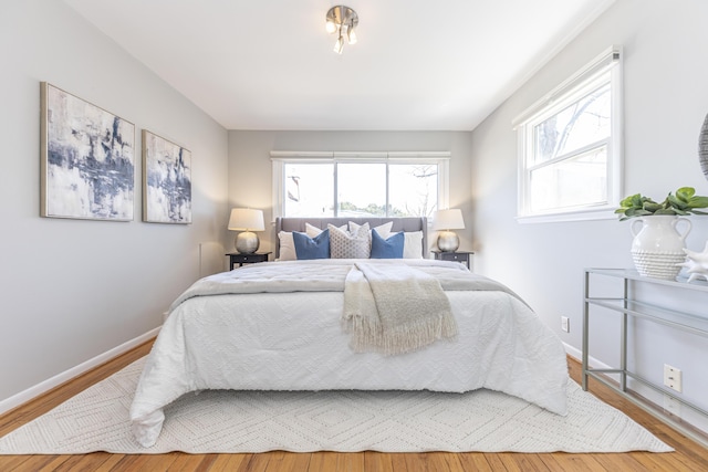 bedroom featuring baseboards and wood finished floors