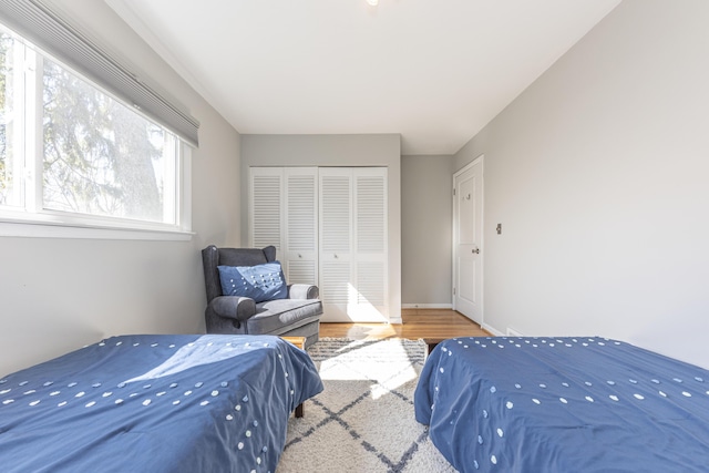 bedroom with a closet, baseboards, and wood finished floors