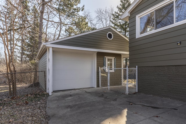 garage with driveway and fence