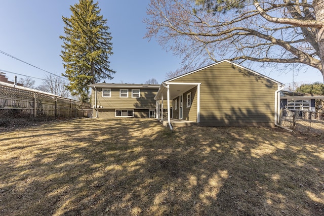 rear view of property with a yard and a fenced backyard