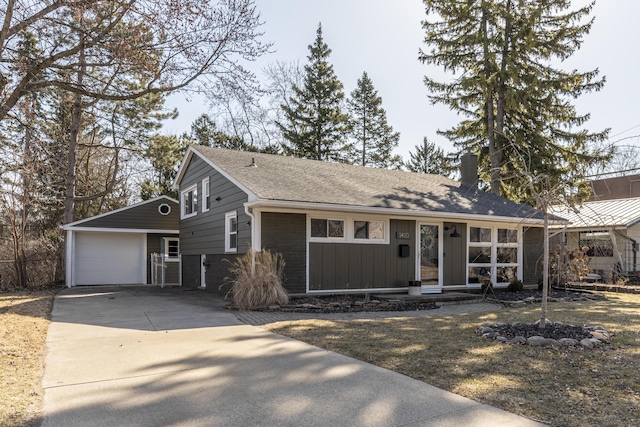 view of front of house with brick siding, concrete driveway, a chimney, and a shingled roof