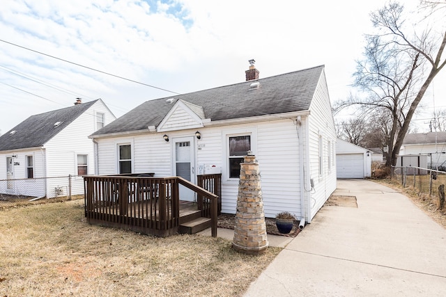 view of front of property with an outbuilding, fence, a garage, and a chimney