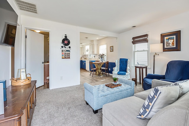 living room featuring visible vents and light carpet