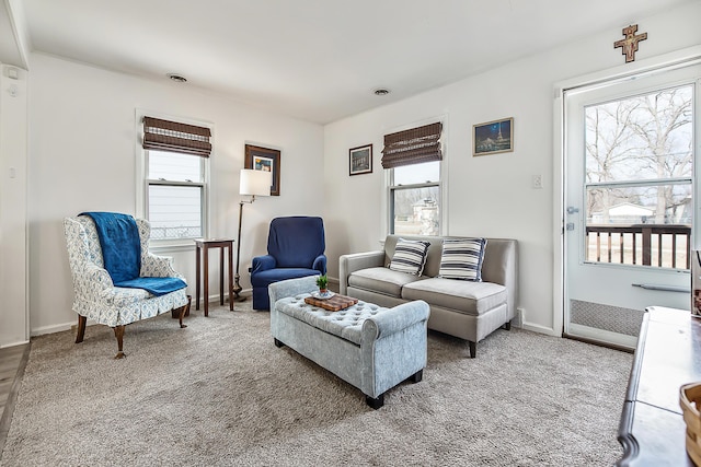 carpeted living area featuring baseboards