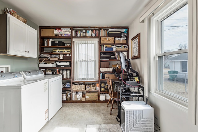 laundry area with a wealth of natural light, cabinet space, and separate washer and dryer