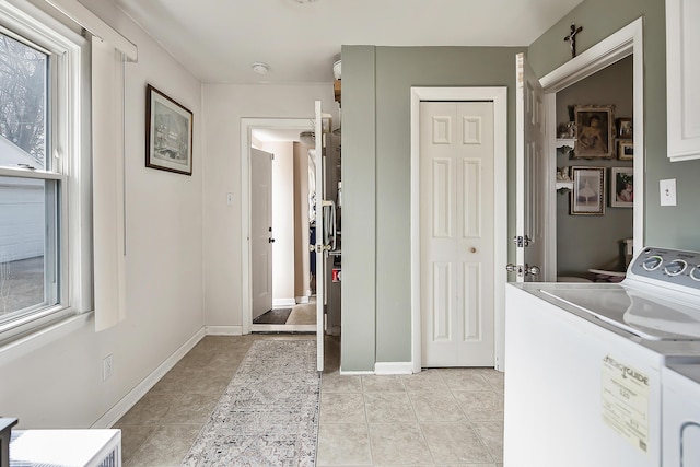 laundry area with light tile patterned floors, laundry area, washer and dryer, and baseboards