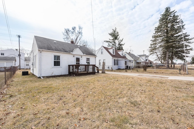 rear view of property with a deck, a lawn, a fenced backyard, and a chimney