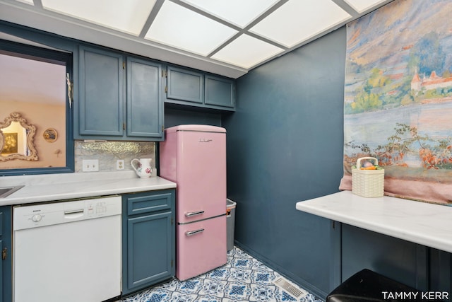 kitchen with blue cabinetry, decorative backsplash, dishwasher, and light countertops