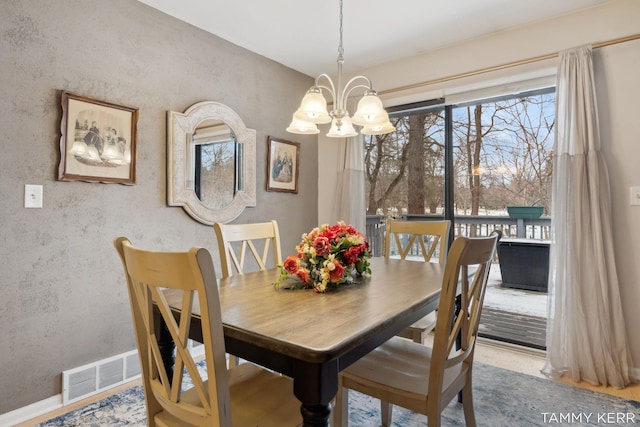 dining space featuring an inviting chandelier and visible vents