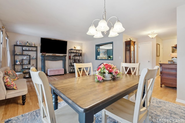 dining area featuring a notable chandelier and light wood-style flooring