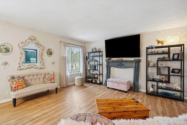 living area with baseboards and wood finished floors