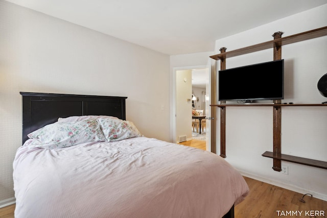 bedroom with light wood-style floors and visible vents