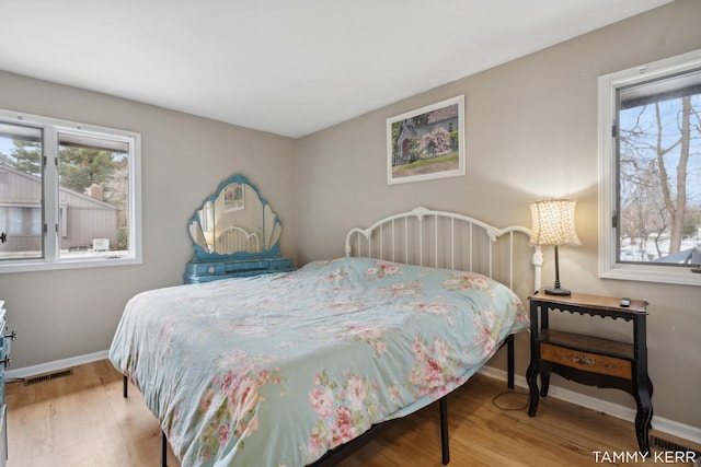 bedroom featuring visible vents, baseboards, and wood finished floors