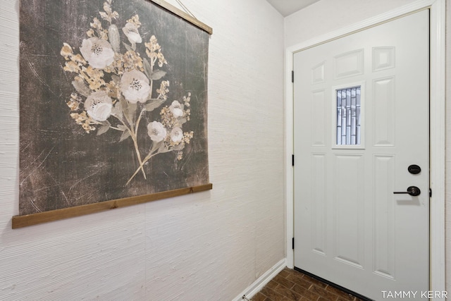 entrance foyer featuring baseboards and brick floor