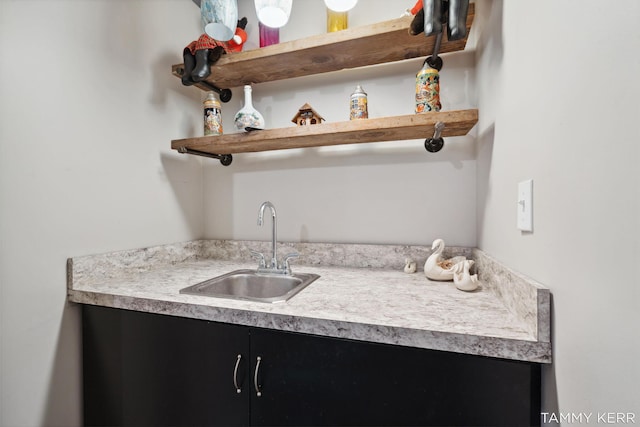 interior space featuring dark cabinets, open shelves, light countertops, and a sink