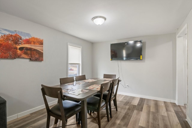 dining area with baseboards and wood finished floors