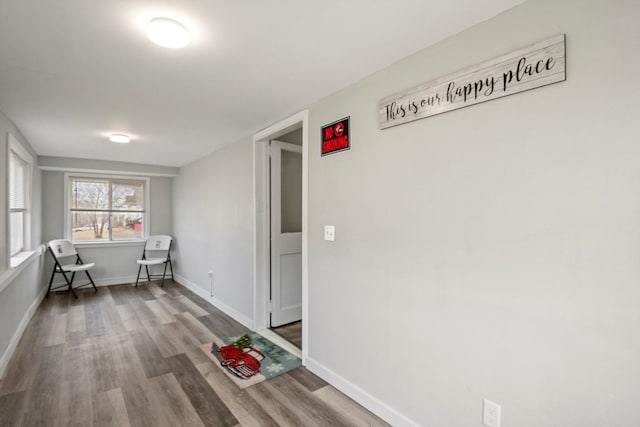 hall with baseboards and wood finished floors