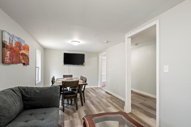 living room with baseboards and light wood-type flooring