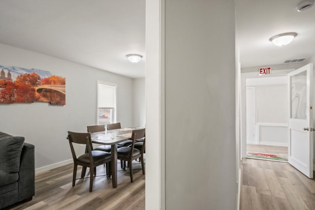 dining space featuring visible vents, baseboards, and wood finished floors