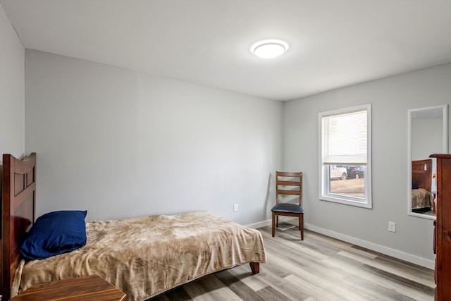 bedroom featuring baseboards and light wood finished floors