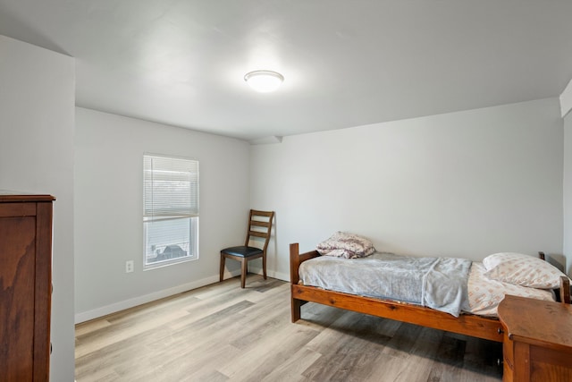 bedroom with baseboards and light wood finished floors