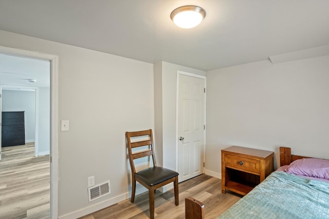 bedroom with visible vents, light wood-style flooring, and baseboards