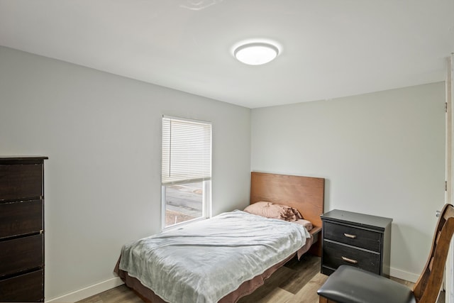 bedroom with baseboards and light wood finished floors