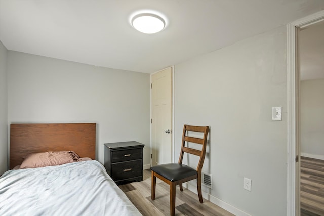 bedroom featuring visible vents, baseboards, and light wood-type flooring