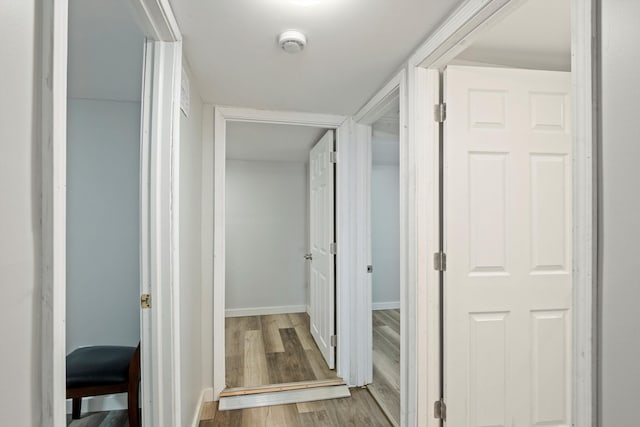 hall featuring baseboards and wood finished floors