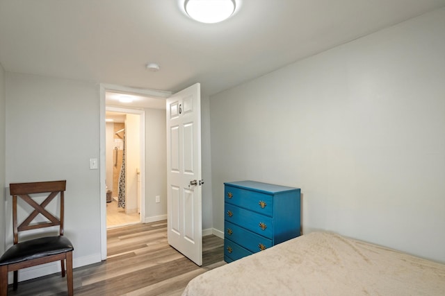 bedroom featuring wood finished floors and baseboards