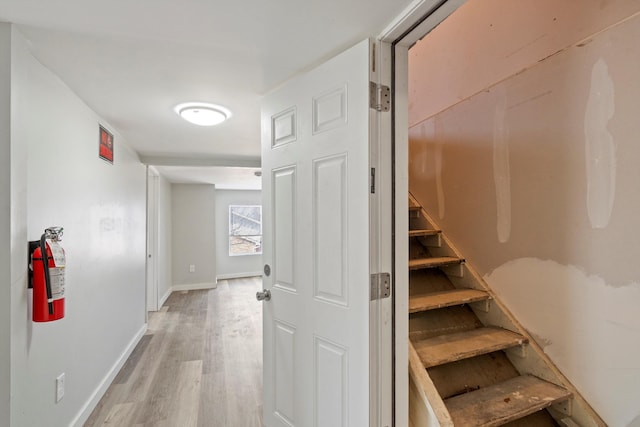 staircase featuring baseboards and wood finished floors