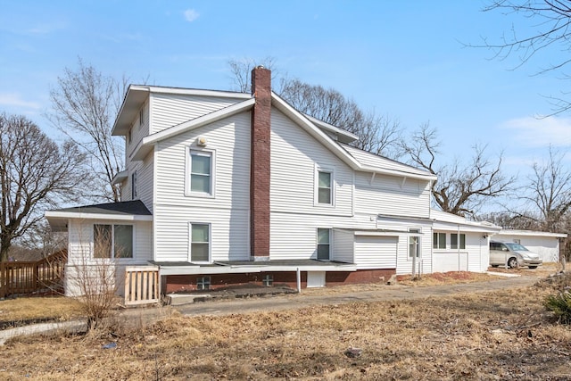 back of house featuring a chimney