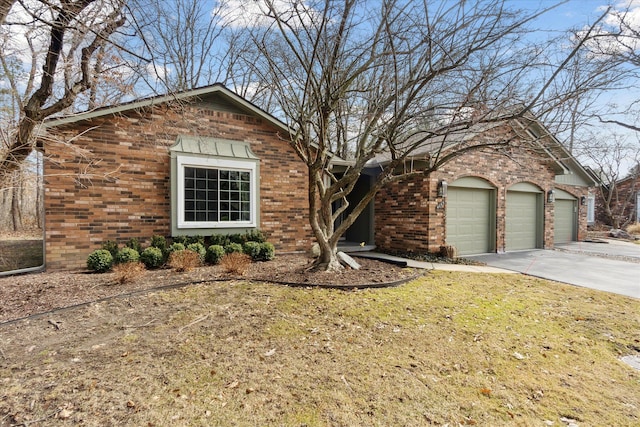 view of front of property featuring brick siding, driveway, a front yard, and a garage