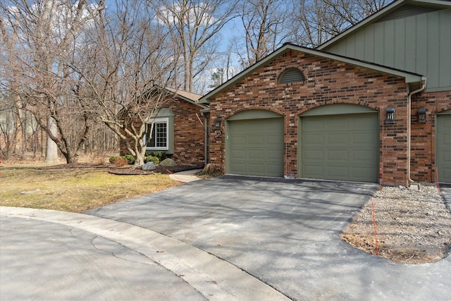 view of front of property featuring a garage, brick siding, and driveway