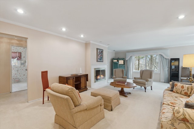 living area with recessed lighting, a glass covered fireplace, light colored carpet, and crown molding